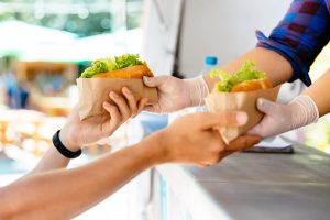 bild på två händer som tar emot mat på en festival